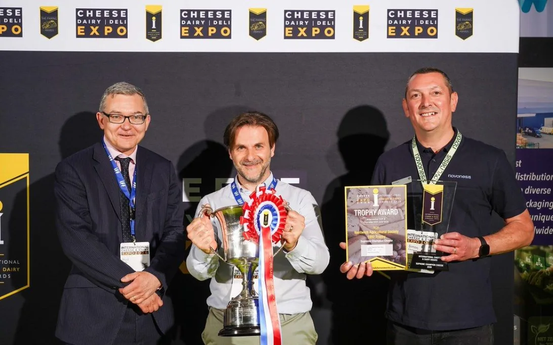 Three men holding a silver trophy cup, rosette and awards at Cheese Dairy Deli Expo