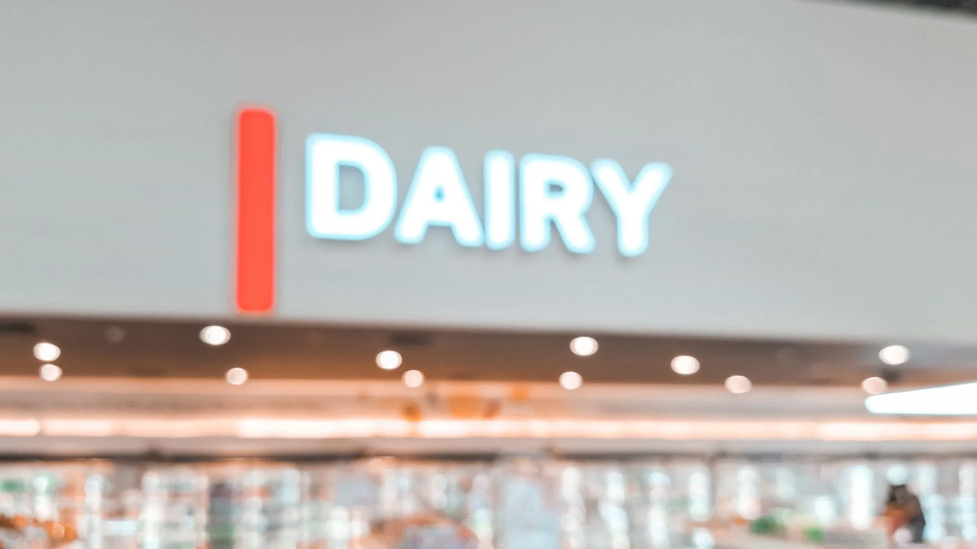Blurred illuminated Dairy sign above a supermarket chilled aisle